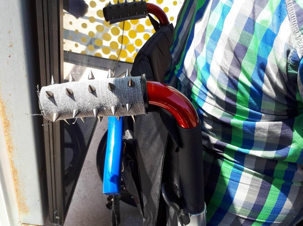 A manual wheelchair displays handles with punk-style spikes invented by John Farnworth